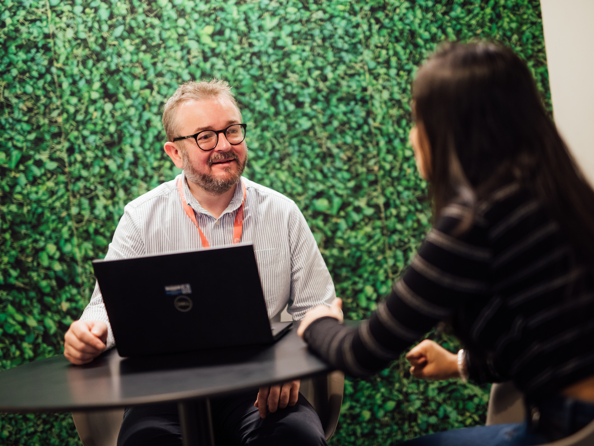 Staff helping student at computer