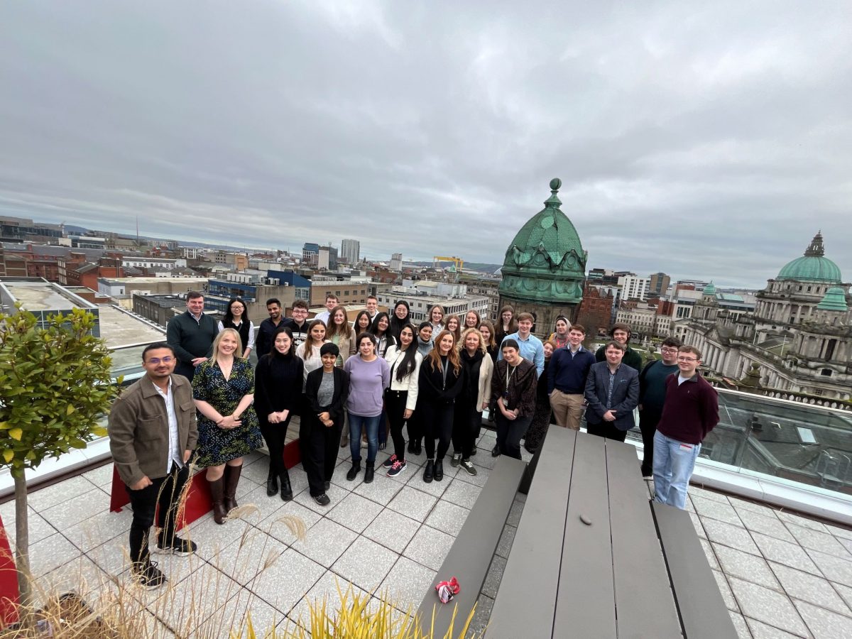 staff and students standing together on a roof terrace