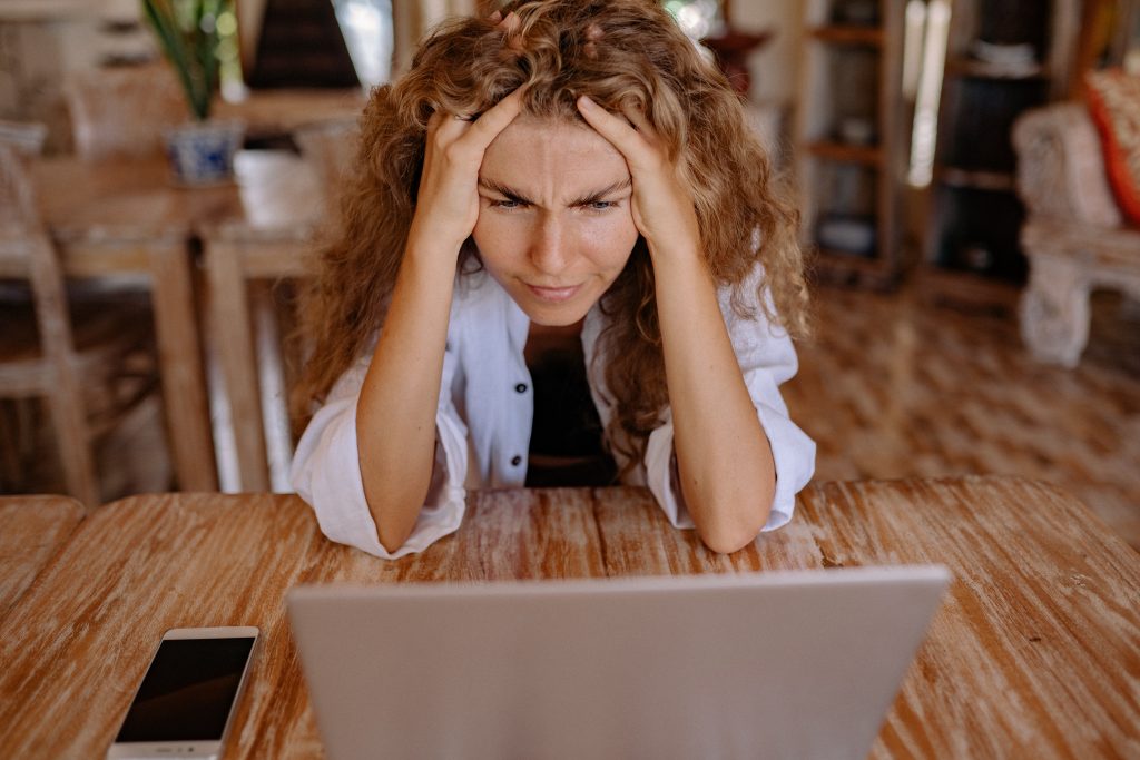 Woman looking at laptop stressed