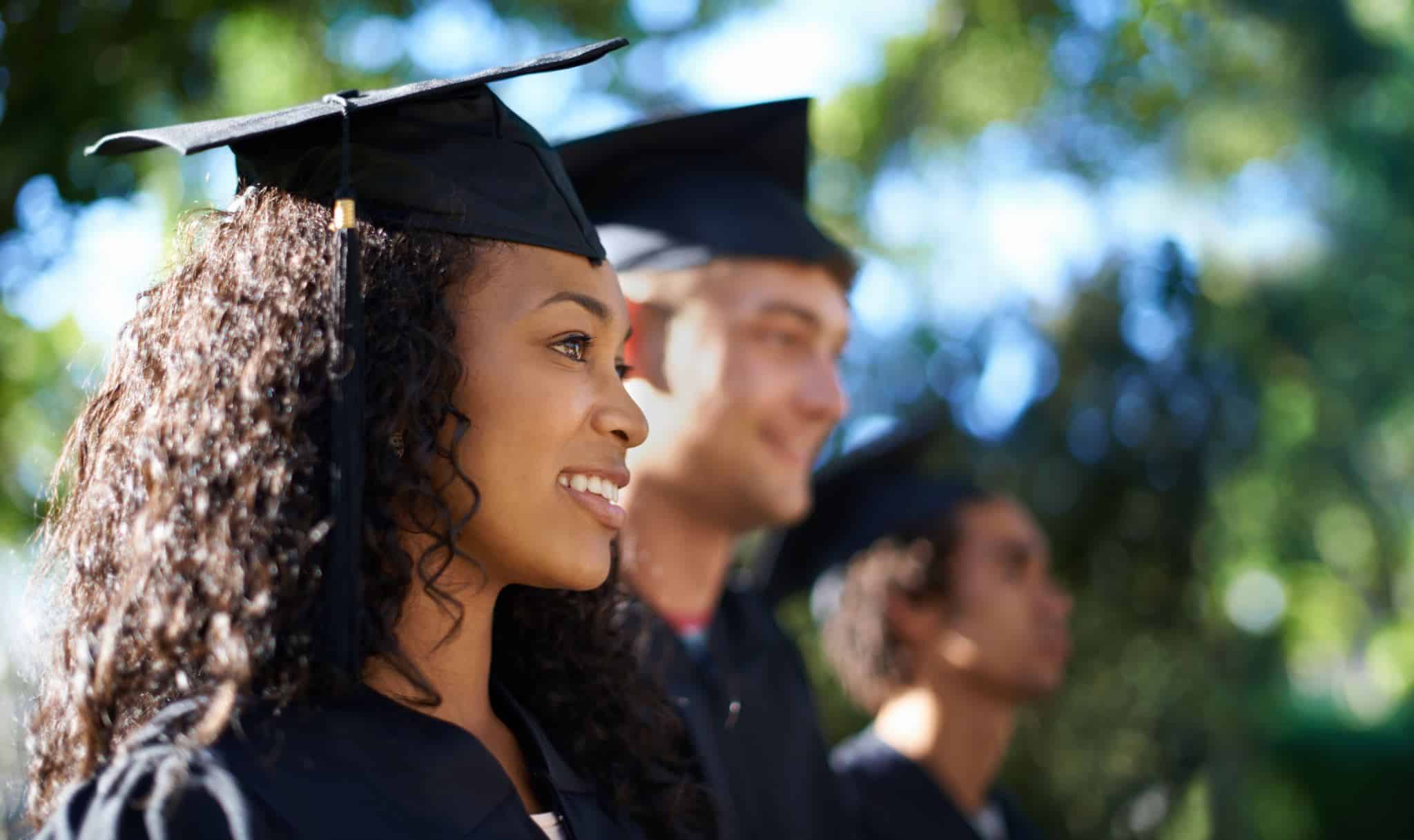 Three students wearing graduation costumes