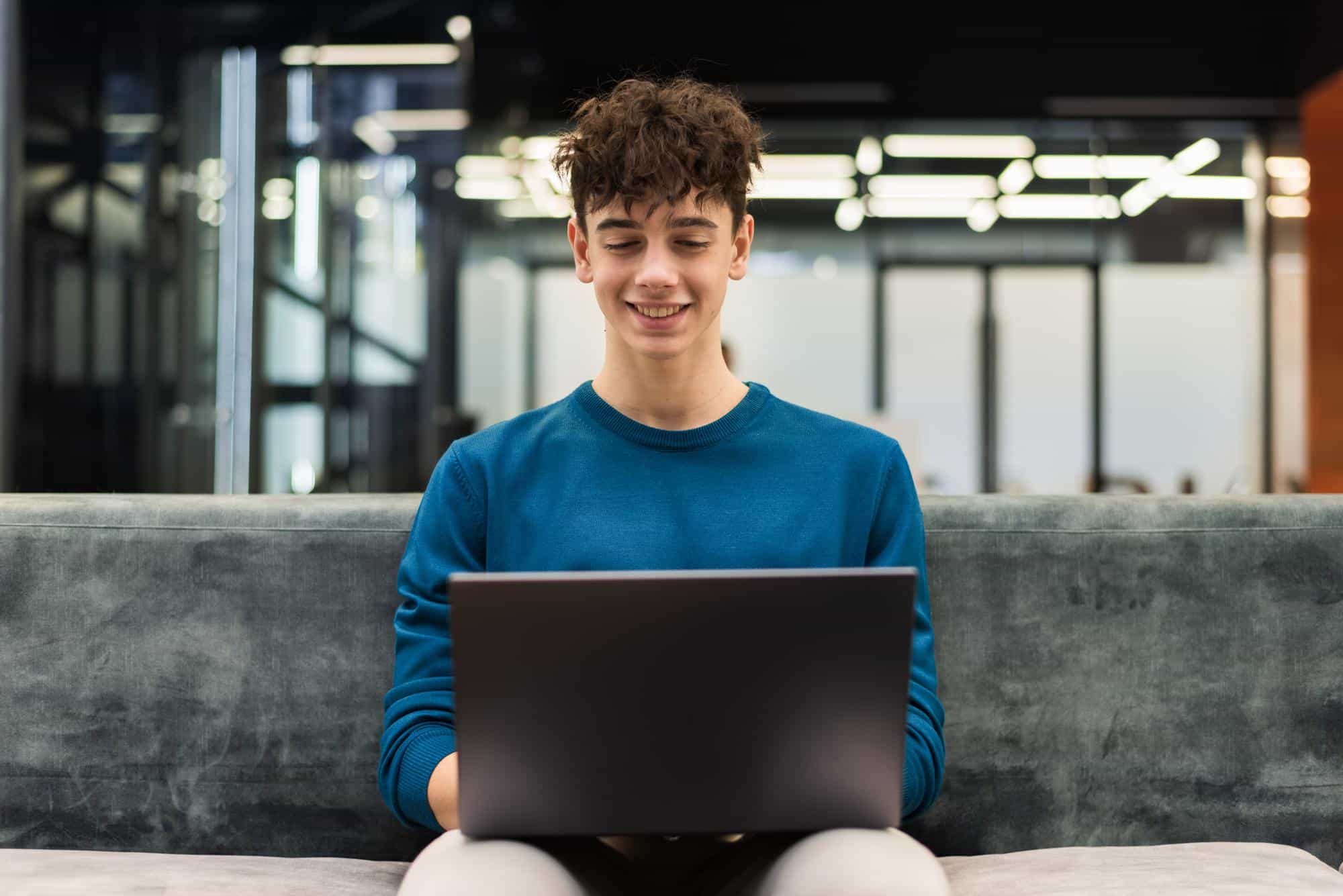 Young man smiling working on a laptop