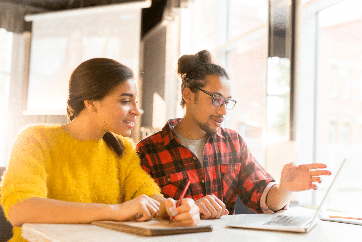 Two young people looking at a laptop