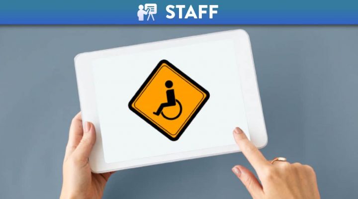 Person using a tablet with an accessibility logo on the screen