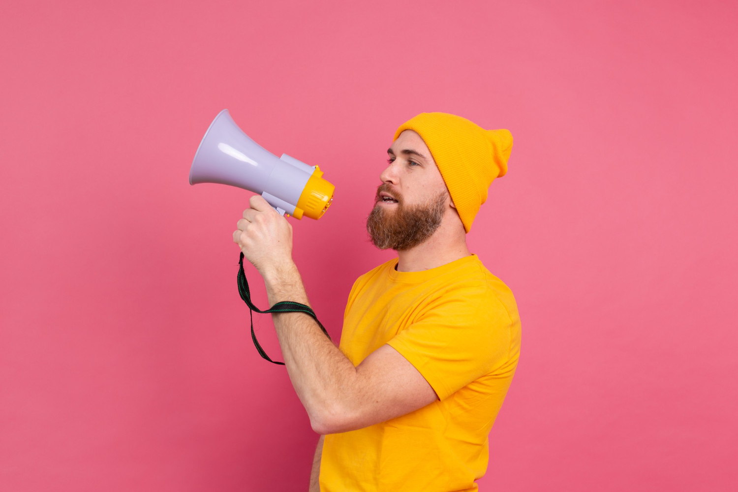 Man shouting in megaphone on pink background