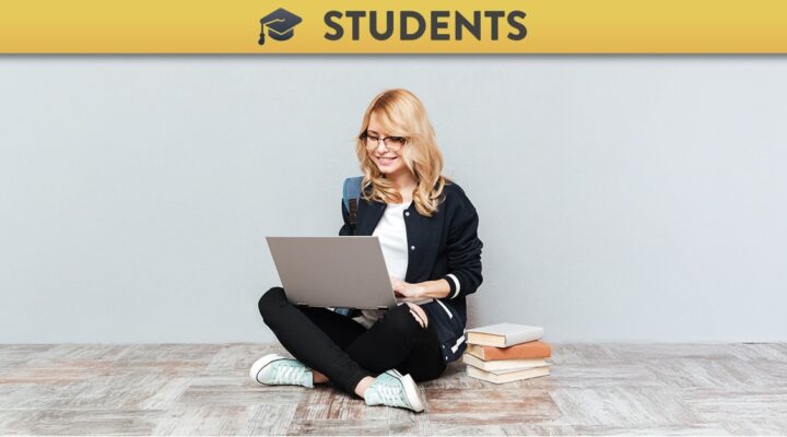 Young woman sitting on the ground using a laptop