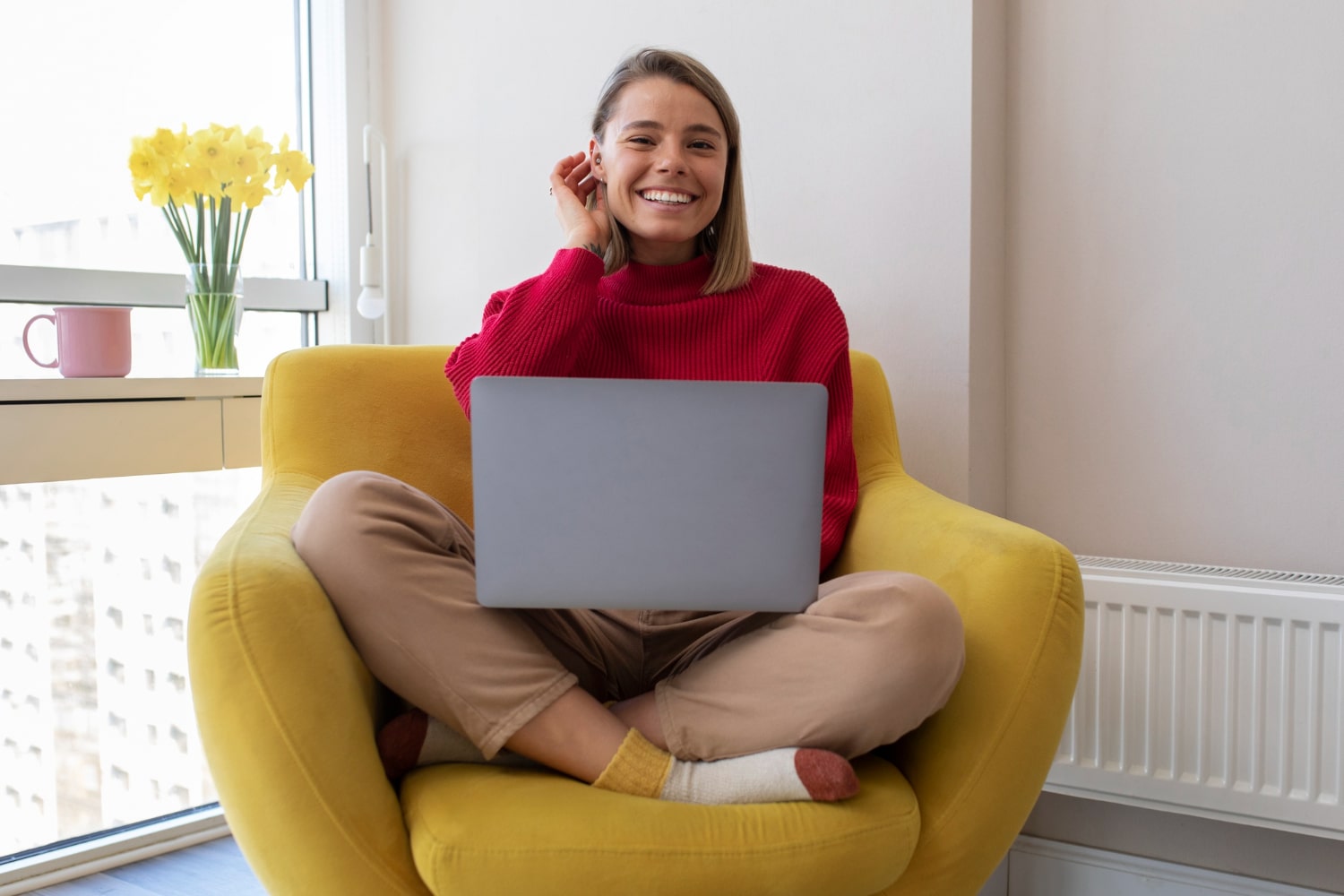 Female sitting on yellow chair with laptop